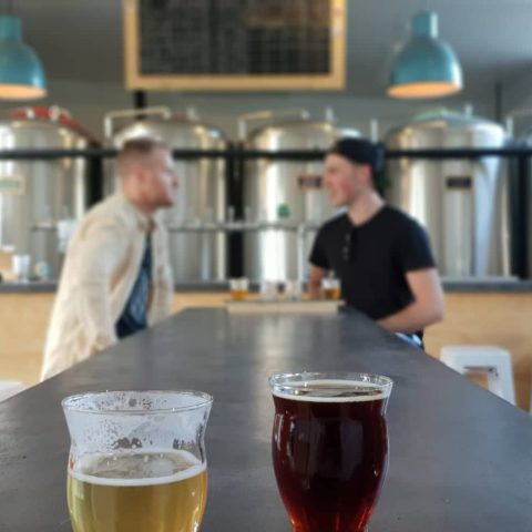 a cup of coffee and a glass of beer on a table