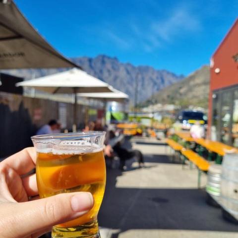 a hand holding a glass of orange juice