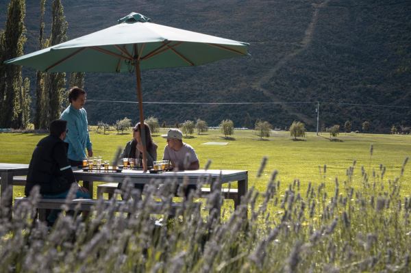 a group of people sitting at a table with a umbrella